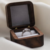 Diamond ring in a black hexagonal jewelry box on a white fabric background